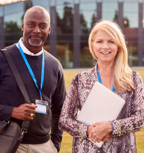 Professional colleagues wearing lanyards standing outdoors
