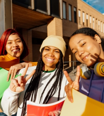 Young women posing with peace signs outdoors