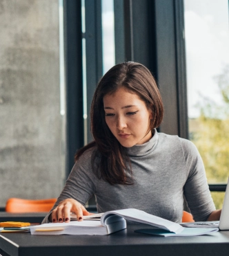 Woman reading textbook at desk